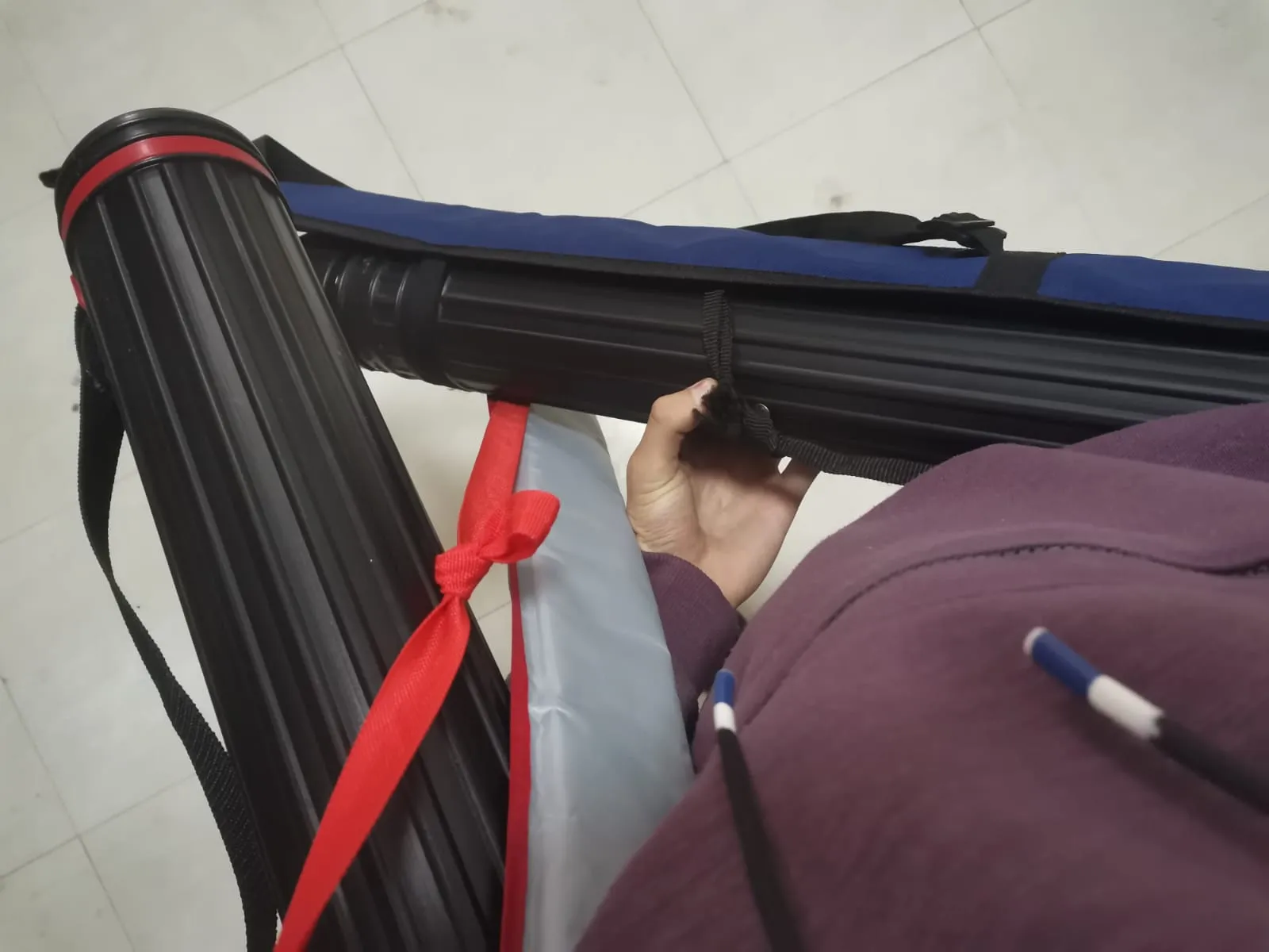Engineering drawing tubes and supplies being carried across a university hallway